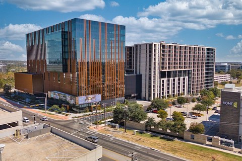A modern building with a glass facade and a brown wooden slat facade.