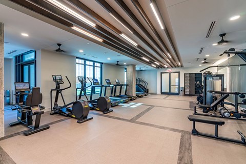 A spacious gym with a variety of equipment and a large mirror on the wall.
