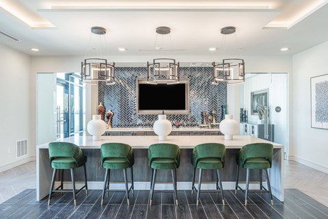 A modern kitchen with green chairs and a central island.