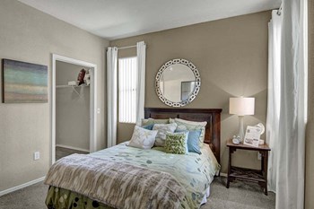 A bedroom with a large closet and windows overlooking the property Pala Mesa Bedroom - Photo Gallery 6