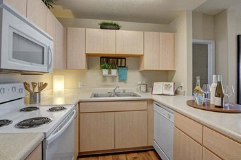 A kitchen with light cabinets and white appliances Pala Mesa Kitchen - Photo Gallery 2