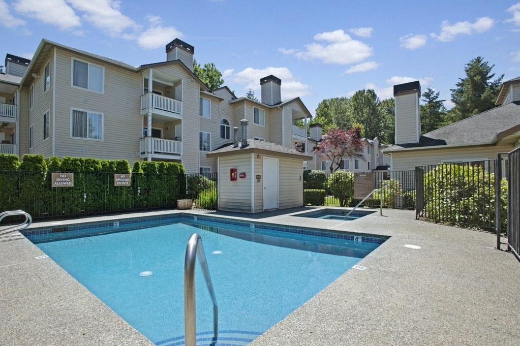 A swimming pool in front of apartment buildings.