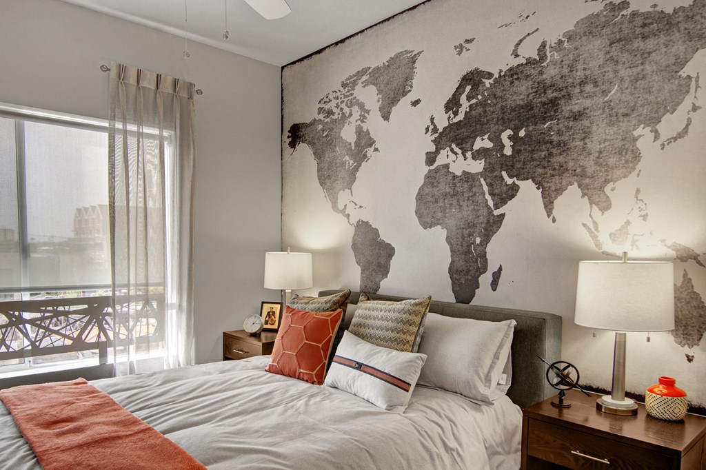 a bedroom with a bed and a world map on the wall