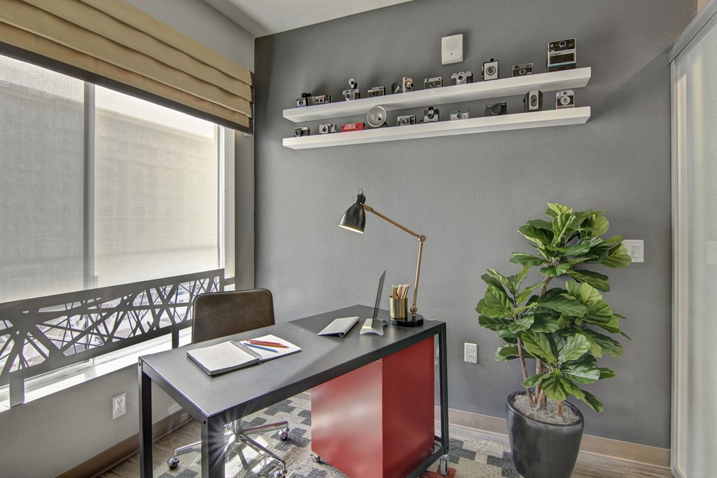 a home office with a desk and a plant