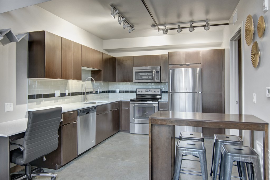 a kitchen with wooden cabinets and stainless steel appliances
