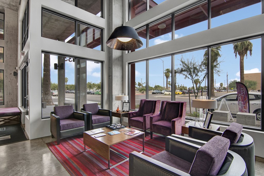 a lobby with purple chairs and a red rug