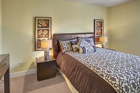 a bedroom with a large bed and two night stands with lamps