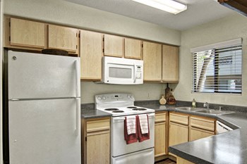 A kitchen with light cabinets and white appliances Reserve at Arrowhead Kitchen - Photo Gallery 3