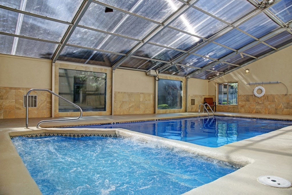a swimming pool with a glass ceiling and tile floor