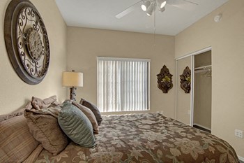 A bedroom with a window overlooking the property and a ceiling fan Property Image