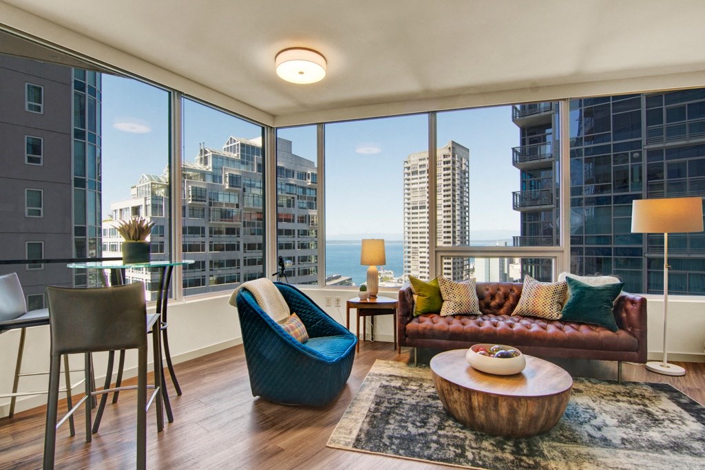 a living room with a large window and a view of the ocean