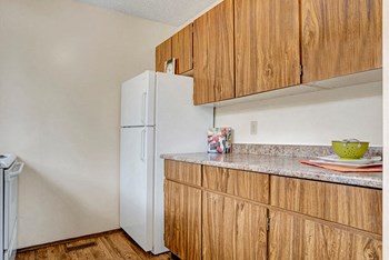 A kitchen with white appliances and dark cabinetry Ventana Apartment Homes Kitchen - Photo Gallery 4