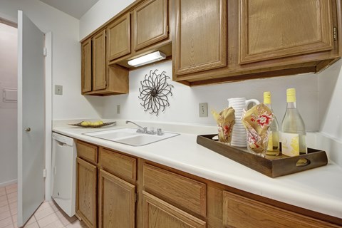 A kitchen with wooden cabinets and a white counter.
