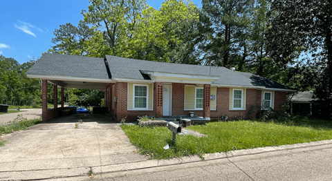 A house with a driveway and a mailbox in front.
