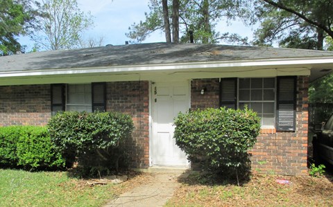 the front of a brick house with a white door
