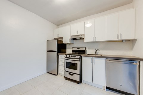 A kitchen with white cabinets and stainless steel appliances.