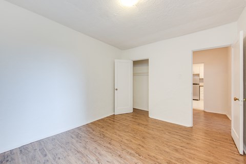 A room with a white wall and a wooden floor.