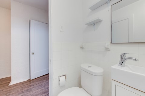 A white toilet sits next to a white sink in a bathroom.