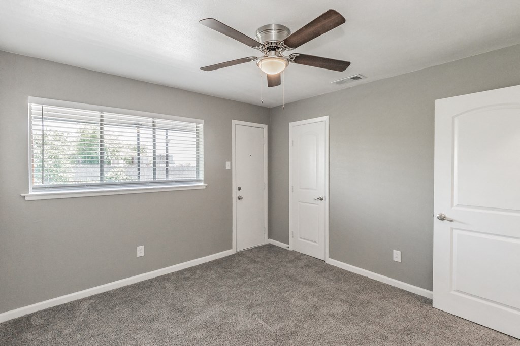 Bedroom with ceiling fan and neutral tones at Chapel Creek Apartments Dallas