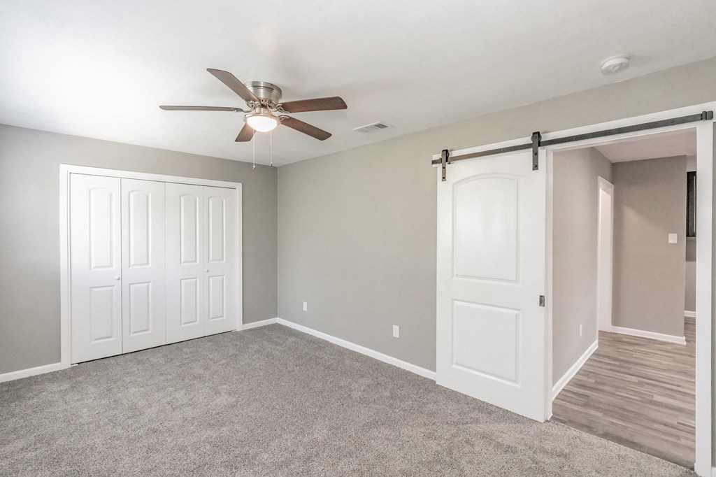 Bedroom with ceiling fan and neutral tones at Chapel Creek Apartments Dallas
