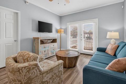 A living room with a blue couch and a television.