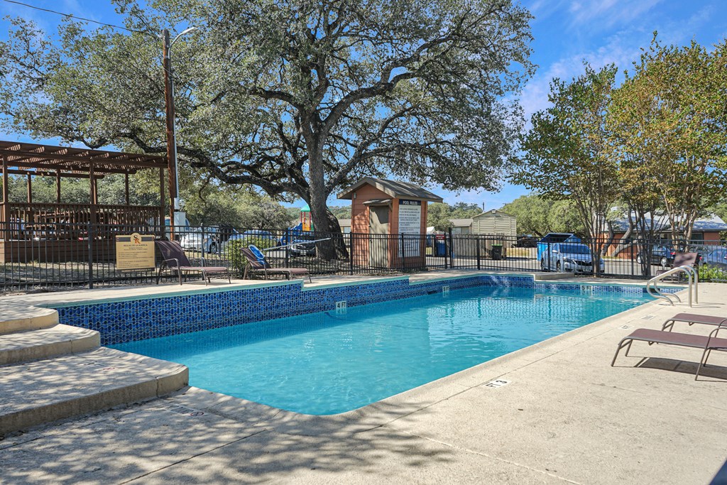 Modern swimming pool with lounge seating at Sierra Ranch Apartments in San Antonio, TX.