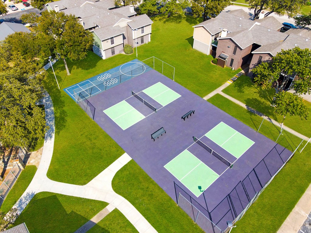 Pickleball courts next to pool area at Station 121 Apartments