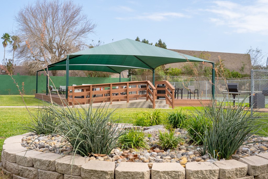 a gazebo in a park with benches - Borders Apartments Brownsville TX