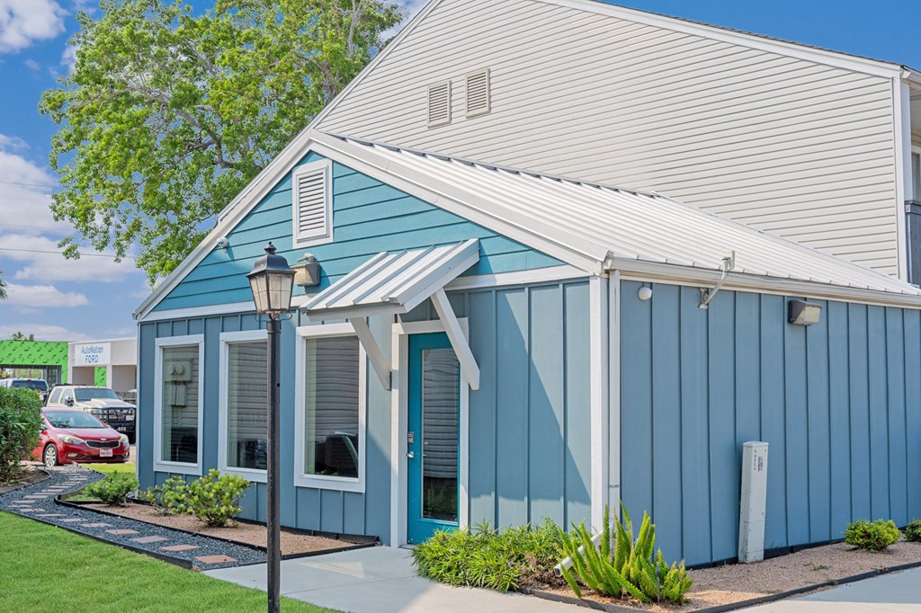 Exterior of fitness center with blue siding at Towne Oaks Apartments.