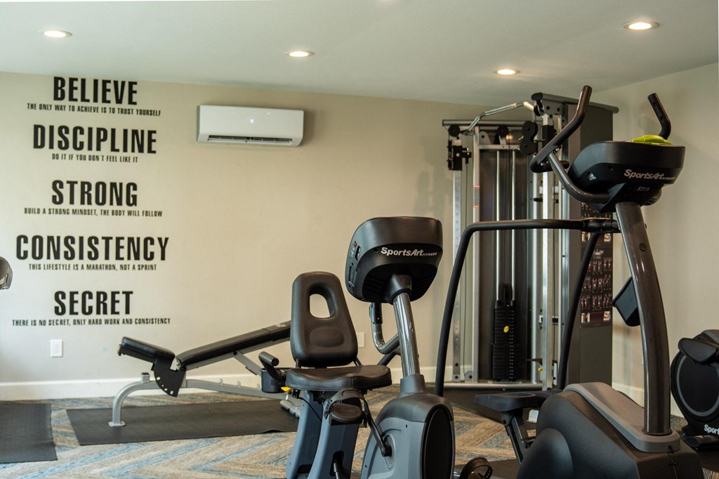 a gym with exercise equipment and a poster on the wall
