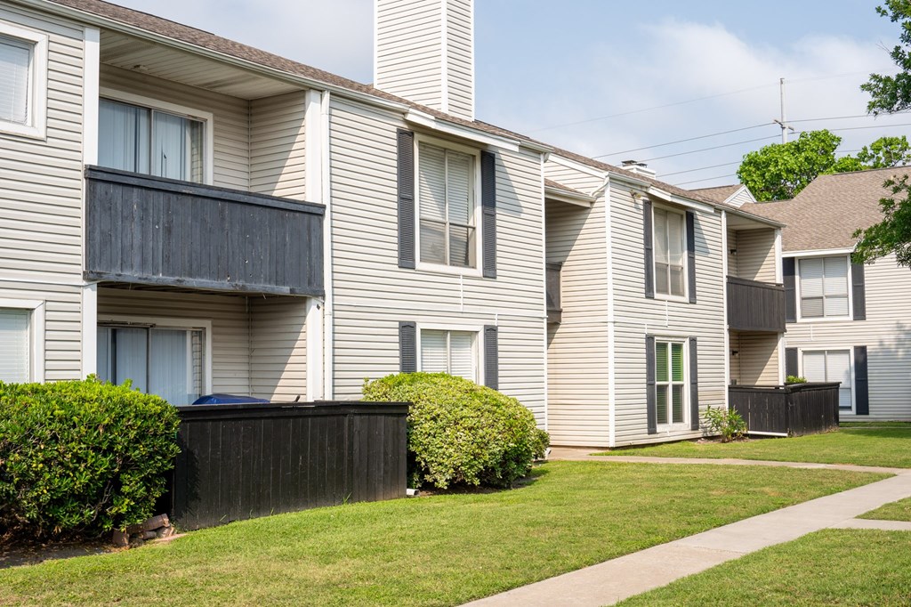 a row of houses with white siding and a sidewalk