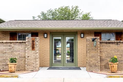 Leasing office entrance with double glass doors at Greenbriar Place Apartments.