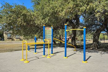 A blue and yellow outdoor gym equipment set up in a park.