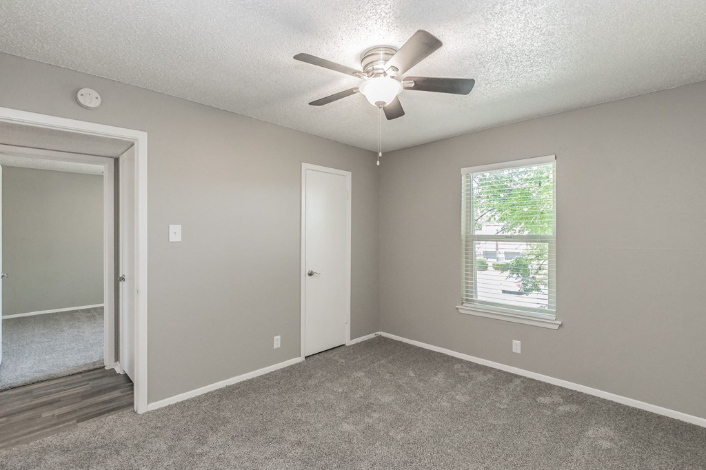 Bedroom with ceiling fan and plush carpet at Davis Park Apartments