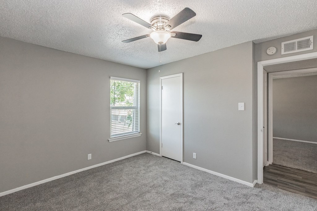 Bedroom with ceiling fan and plush carpet at Davis Park Apartments