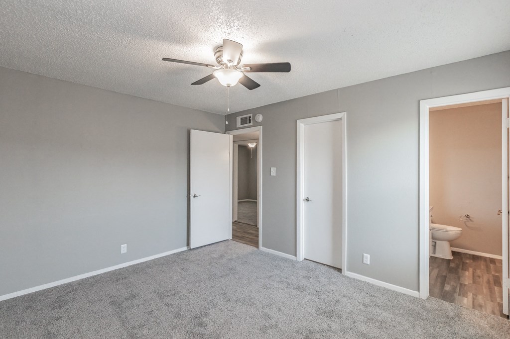Bedroom with ceiling fan and plush carpet at Davis Park Apartments