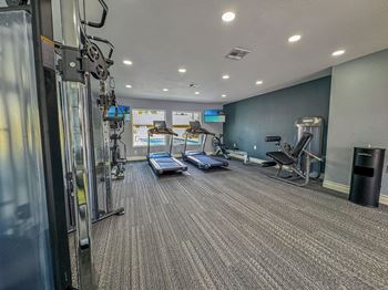 A gym with treadmills, elliptical machines, and other exercise equipment.