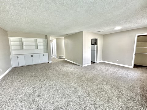 Large living room with grey carpet and bright natural light at Greenbriar Place 55+ Senior Apartments in Corpus Christi.