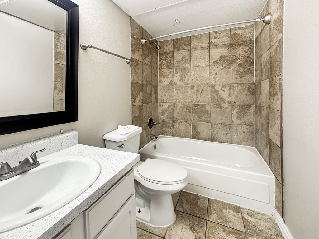 A bathroom with a white toilet, sink, and bathtub.