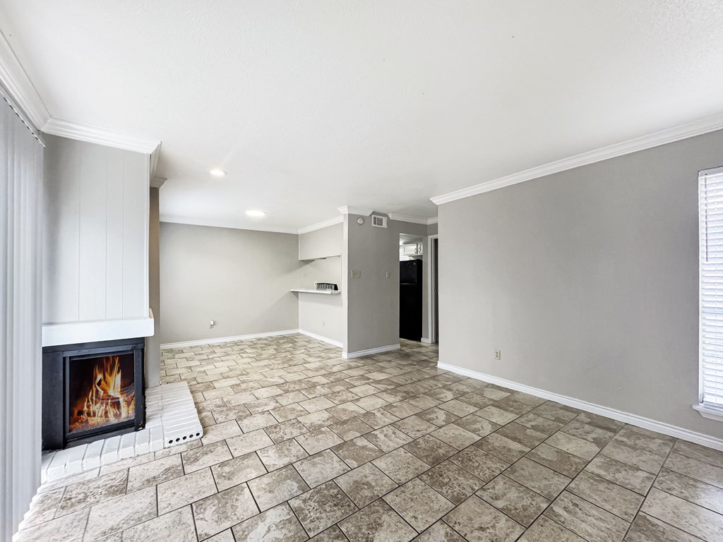 A room with a fireplace and tile flooring.