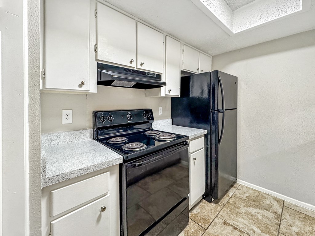 Kitchen with stove, refrigerator, and ample counter space at Towne Oaks Apartments.