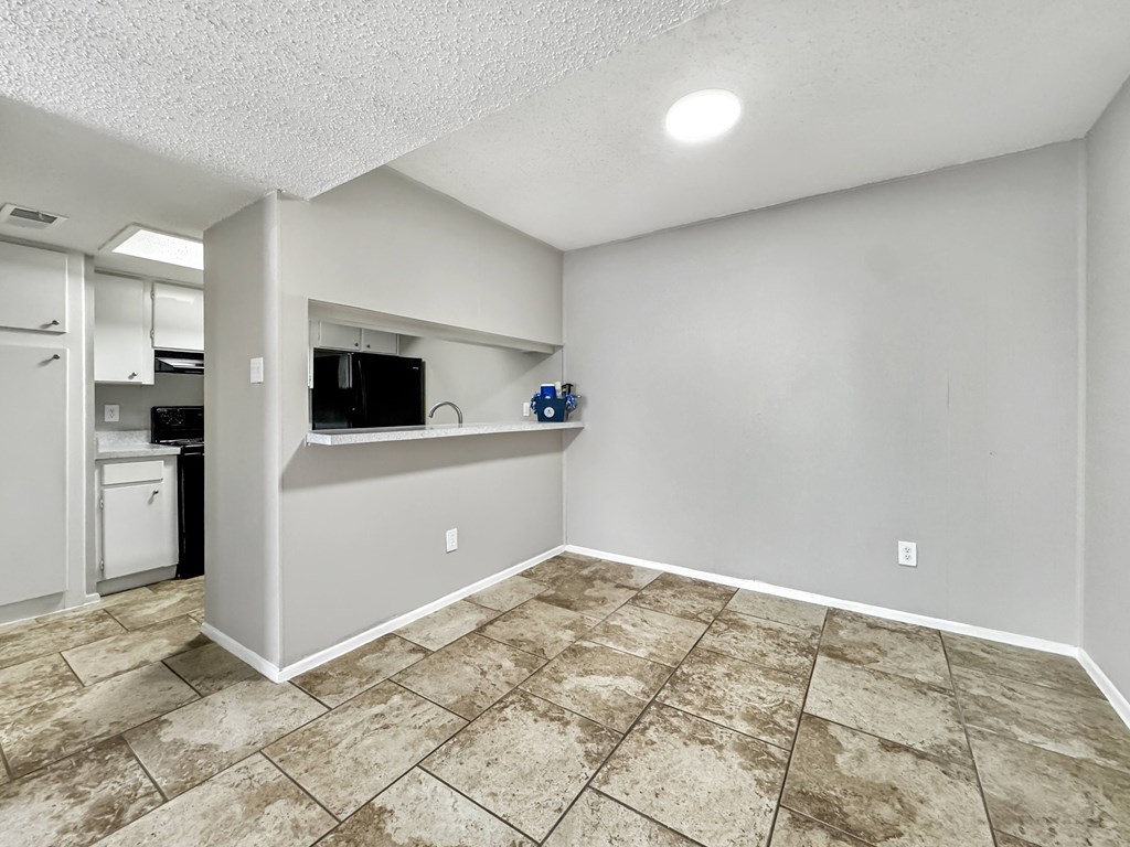 Dining space with tile flooring and breakfast bar at Towne Oaks Apartments.