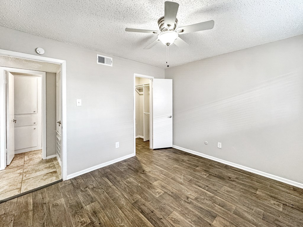 Bedroom with ceiling fan and wood-style vinyl flooring at Towne Oaks Apartments