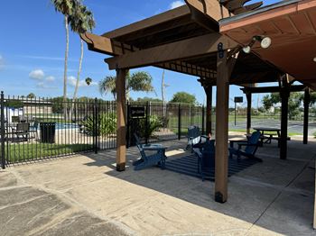 a pavilion with picnic tables in front of a swimming pool