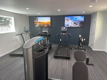 a gym with two machines and two televisions in a building