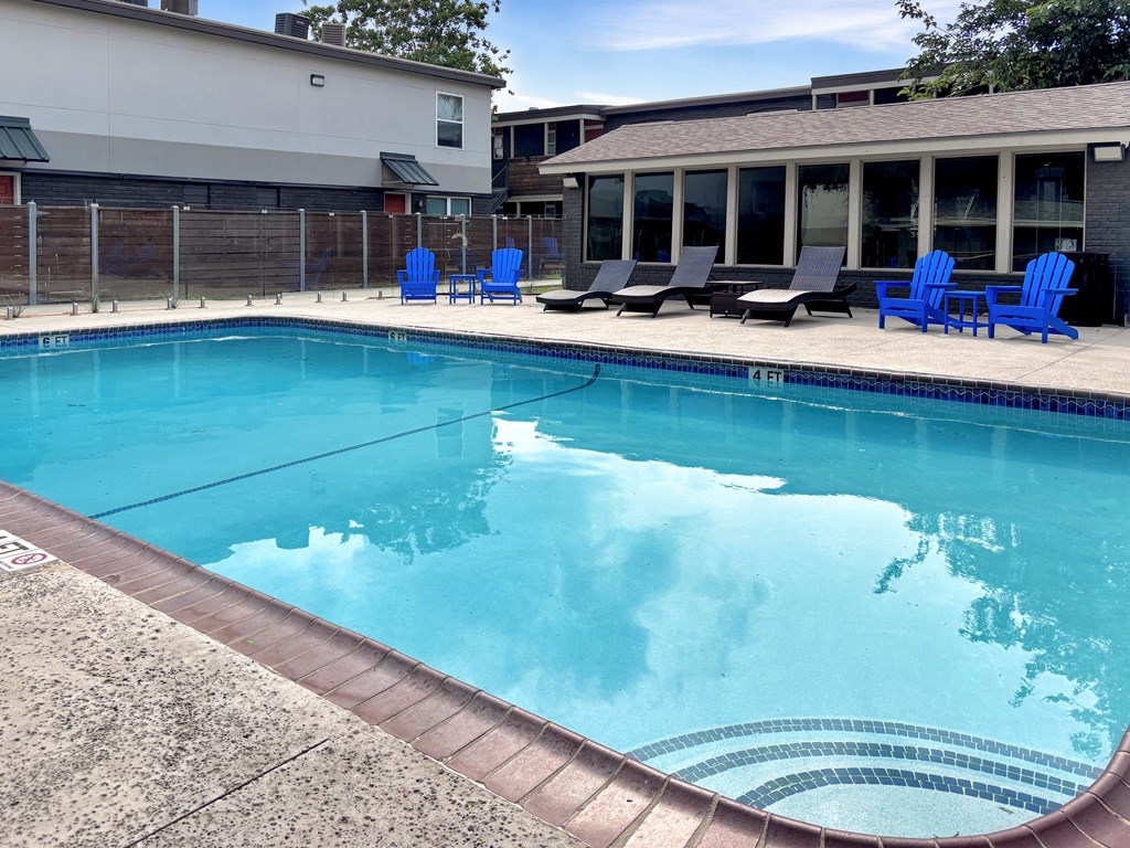 Swimming pool with deck chairs at Christy Estates Apartments