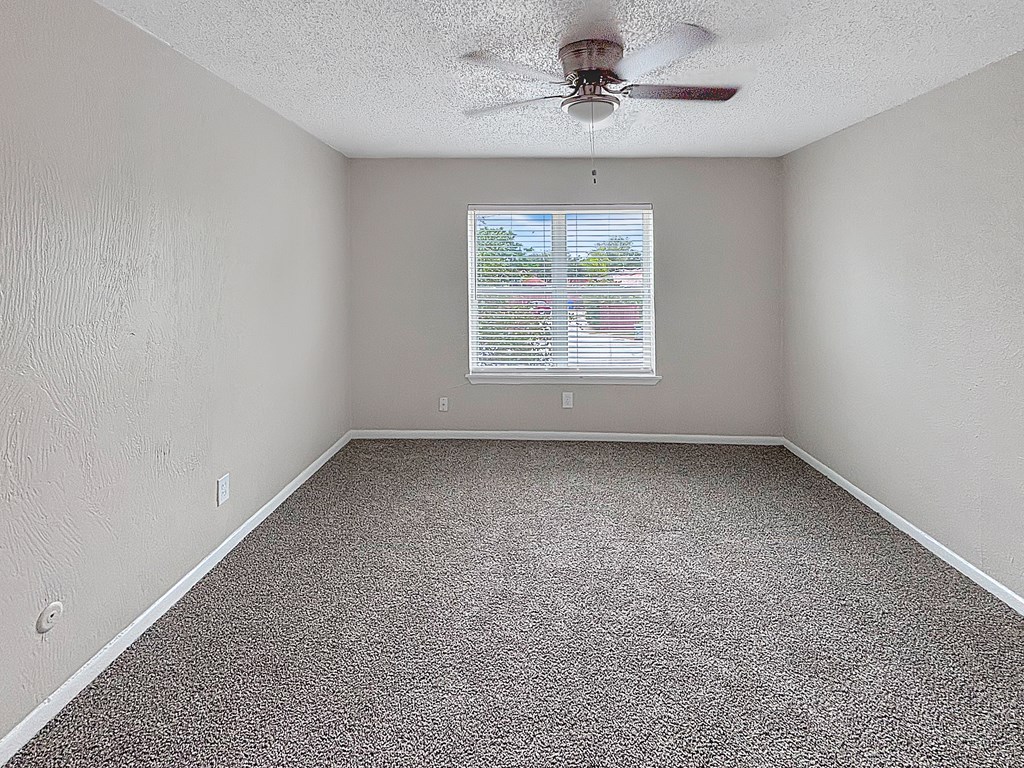 Bedroom with ceiling fan and single window at Christy Estates Apartments