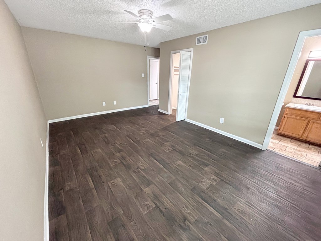 A room with wood style flooring and a ceiling fan.