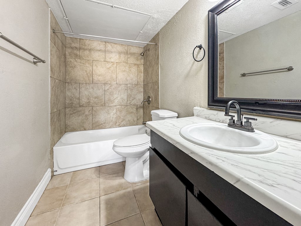 Bathroom with white tub and tile surround – Borders Apartments Brownsville TX