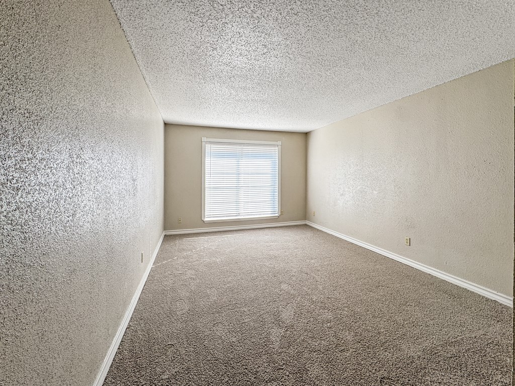 Bedroom with carpet flooring and large window – Borders Apartments Brownsville TX